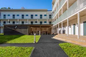 Flerbostadfastighet med vit fasad och mörka dörrar | Nivika Fastigheter AB (publ)