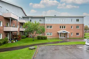 Flerbostadshus med orange tegelfasad, grå träfasad och vita fönster | Nivika Fastigheter AB (publ)