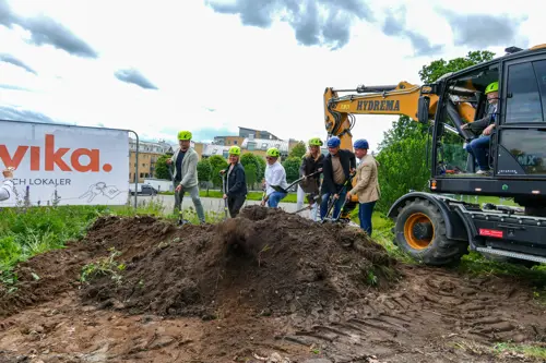 Grävmaskin samt personer som håller i spadar | Nivika Fastigheter AB (publ)