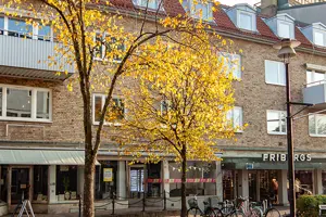 Flerbostadsfastighet med tegelfasad och vita fönster, kommersiella lokaler på första våningen | Nivika Fastigheter AB (publ)