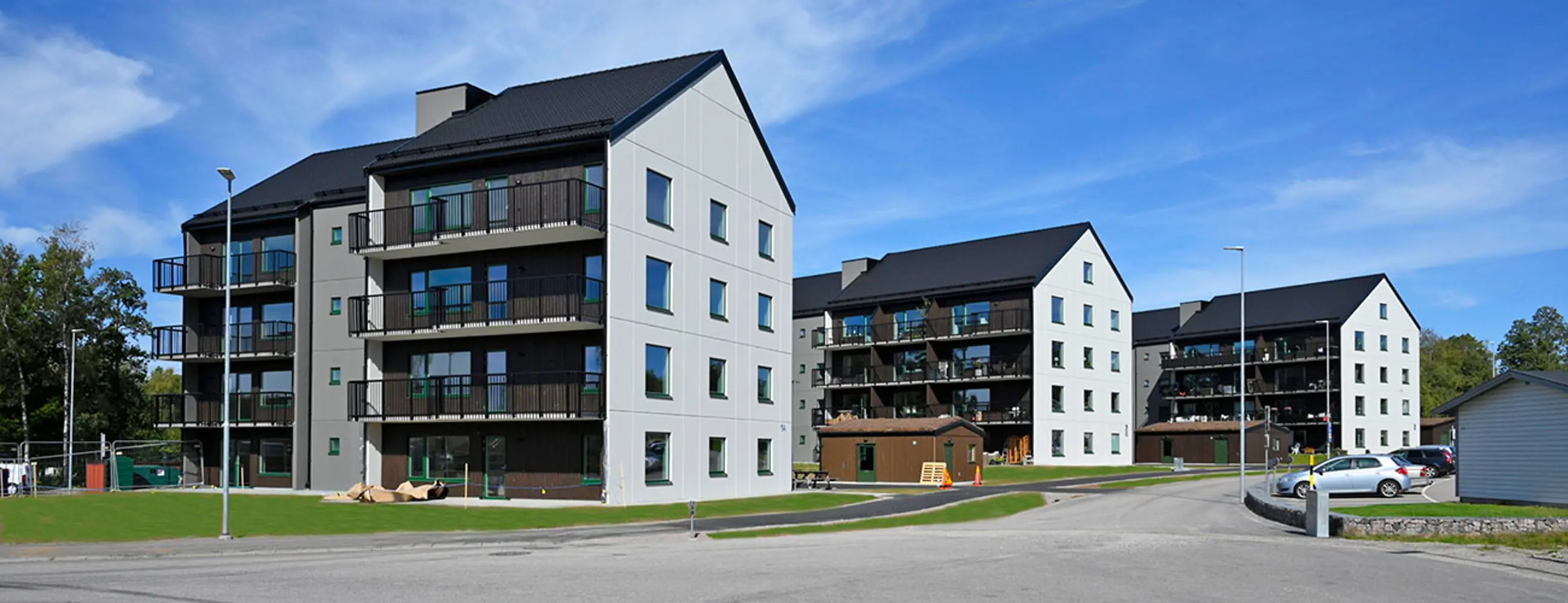 Flerbostadshus med brun och vit fasad, svart tak | Nivika Fastigheter AB (publ)